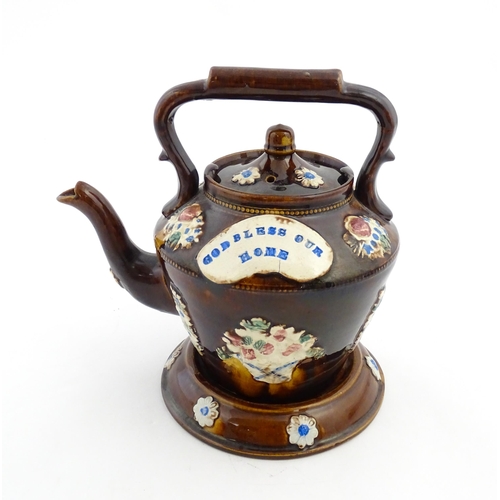 160 - A Victorian Measham bargeware teapot on stand decorated with baskets of flowers and bearing a plaque... 