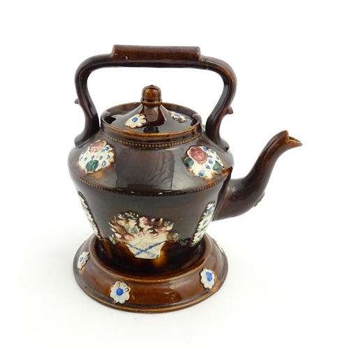 160 - A Victorian Measham bargeware teapot on stand decorated with baskets of flowers and bearing a plaque... 