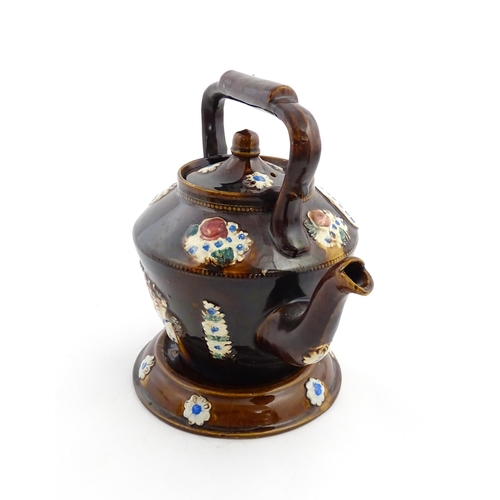 160 - A Victorian Measham bargeware teapot on stand decorated with baskets of flowers and bearing a plaque... 