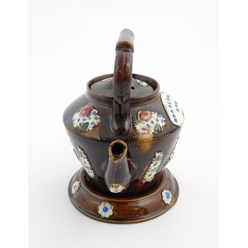 160 - A Victorian Measham bargeware teapot on stand decorated with baskets of flowers and bearing a plaque... 