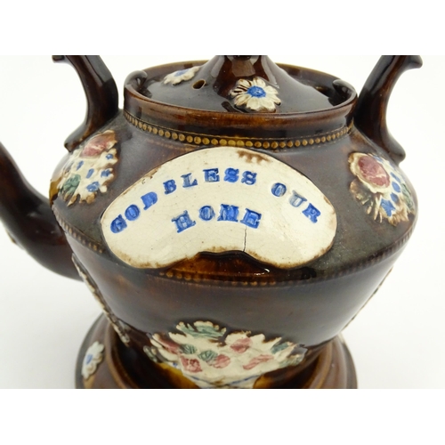 160 - A Victorian Measham bargeware teapot on stand decorated with baskets of flowers and bearing a plaque... 