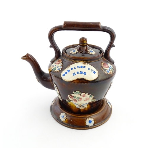 160 - A Victorian Measham bargeware teapot on stand decorated with baskets of flowers and bearing a plaque... 