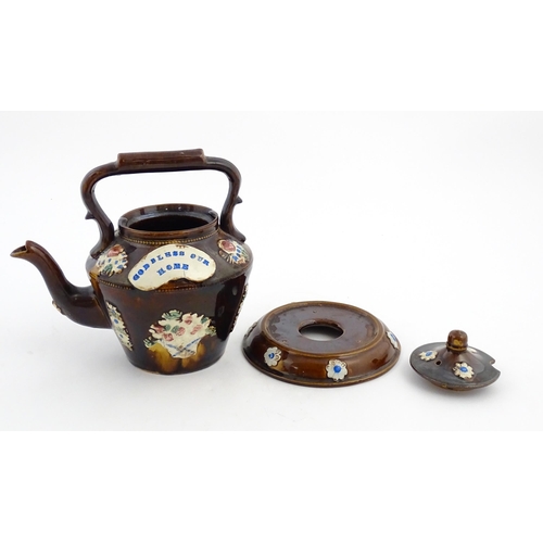 160 - A Victorian Measham bargeware teapot on stand decorated with baskets of flowers and bearing a plaque... 