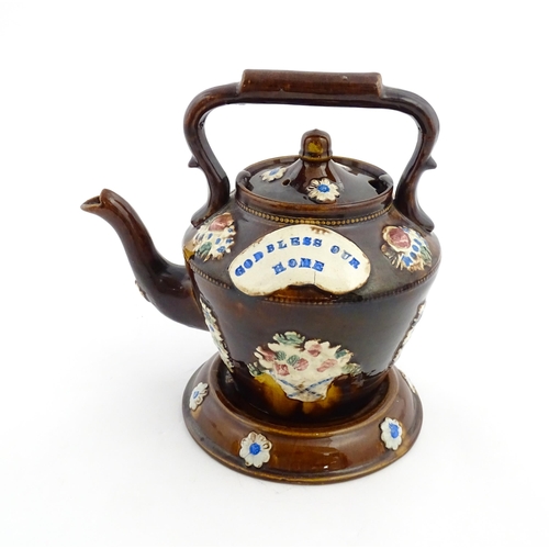 160 - A Victorian Measham bargeware teapot on stand decorated with baskets of flowers and bearing a plaque... 