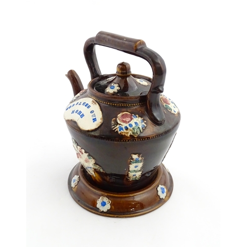 160 - A Victorian Measham bargeware teapot on stand decorated with baskets of flowers and bearing a plaque... 