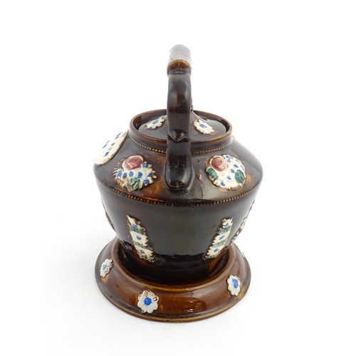 160 - A Victorian Measham bargeware teapot on stand decorated with baskets of flowers and bearing a plaque... 