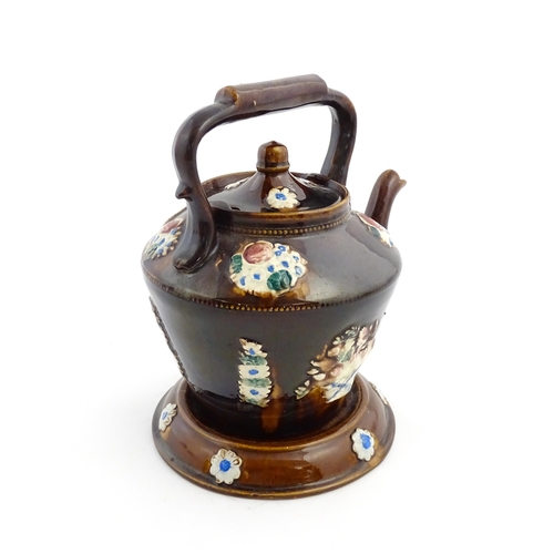 160 - A Victorian Measham bargeware teapot on stand decorated with baskets of flowers and bearing a plaque... 