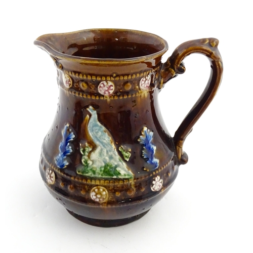 161 - A Victorian Measham bargeware jug decorated with birds and foliage with banded borders. Approx. 6 3/... 