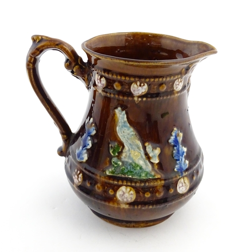 161 - A Victorian Measham bargeware jug decorated with birds and foliage with banded borders. Approx. 6 3/... 