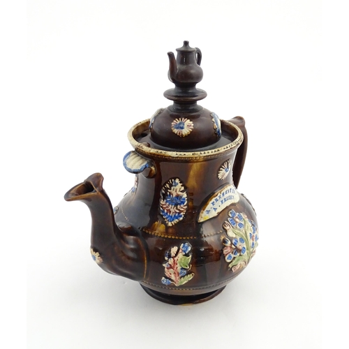 162 - A Victorian Measham bargeware teapot with teapot finial to lid, decorated with flowers and foliage, ... 