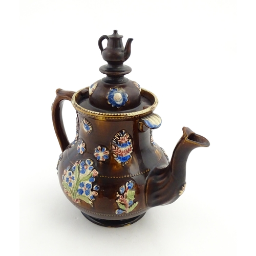 162 - A Victorian Measham bargeware teapot with teapot finial to lid, decorated with flowers and foliage, ... 