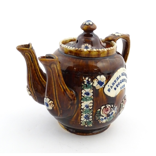 167 - A Victorian Measham bargeware double spout teapot decorated with flowers and foliage, bears plaque t... 