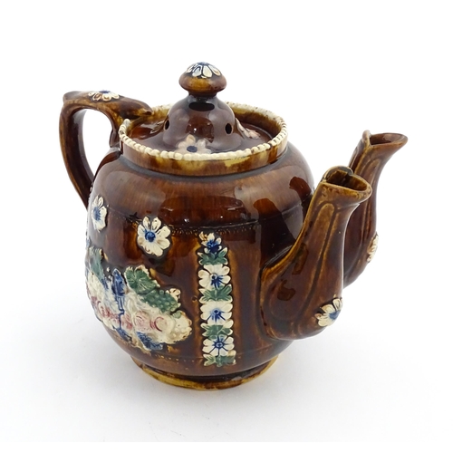 167 - A Victorian Measham bargeware double spout teapot decorated with flowers and foliage, bears plaque t... 