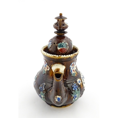 168 - A large Victorian Measham bargeware teapot with teapot finial to lid, decorated with flowers and fol... 