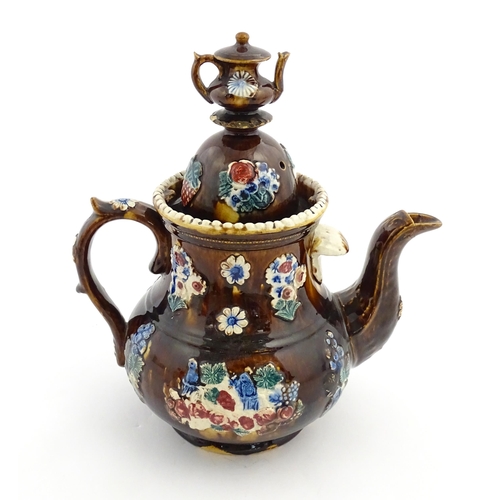 168 - A large Victorian Measham bargeware teapot with teapot finial to lid, decorated with flowers and fol... 