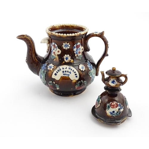 168 - A large Victorian Measham bargeware teapot with teapot finial to lid, decorated with flowers and fol... 