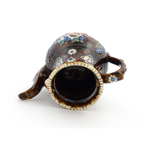 168 - A large Victorian Measham bargeware teapot with teapot finial to lid, decorated with flowers and fol... 