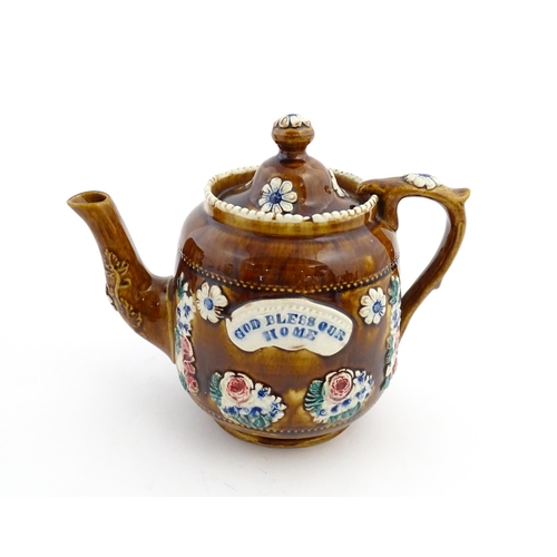 172 - A Victorian Measham bargeware teapot decorated with a basket of flowers and foliage, bearing plaque ... 