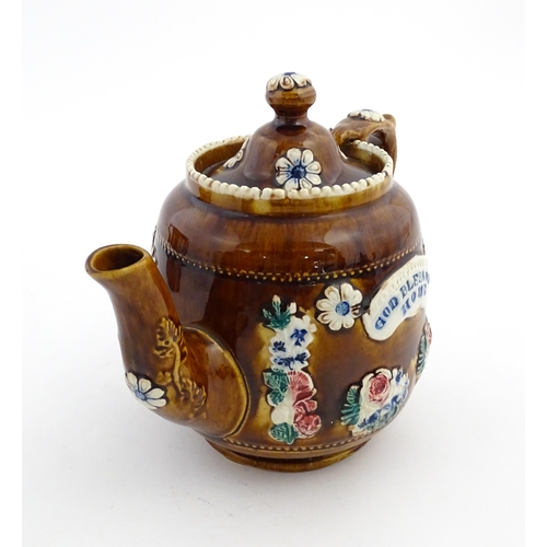 172 - A Victorian Measham bargeware teapot decorated with a basket of flowers and foliage, bearing plaque ... 