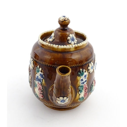 172 - A Victorian Measham bargeware teapot decorated with a basket of flowers and foliage, bearing plaque ... 