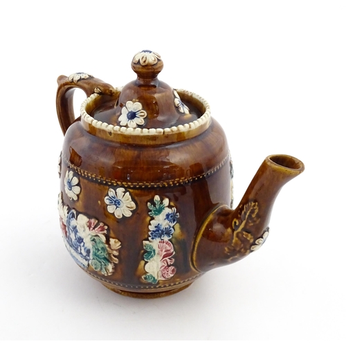 172 - A Victorian Measham bargeware teapot decorated with a basket of flowers and foliage, bearing plaque ... 