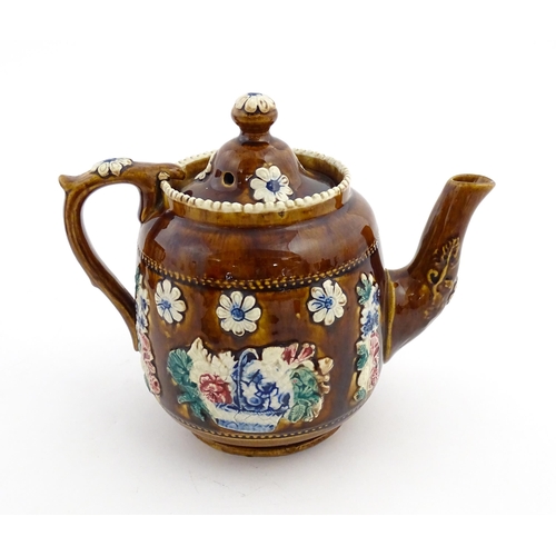 172 - A Victorian Measham bargeware teapot decorated with a basket of flowers and foliage, bearing plaque ... 