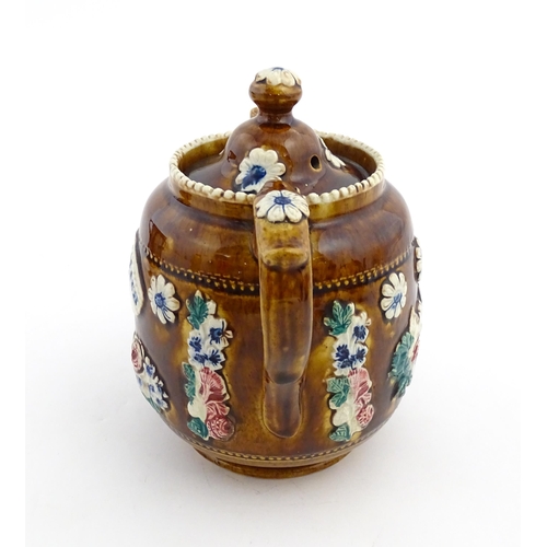 172 - A Victorian Measham bargeware teapot decorated with a basket of flowers and foliage, bearing plaque ... 