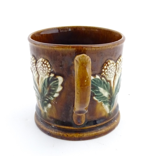 173 - A Victorian Measham bargeware mug decorated with flowers and bearing plaque titled A Present to John... 