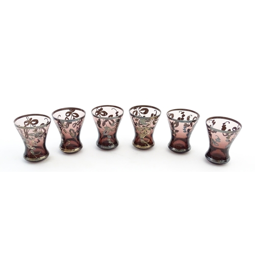 212 - An amethyst glass decanter and six tot glasses with silvered detail. Together with a further six gla... 