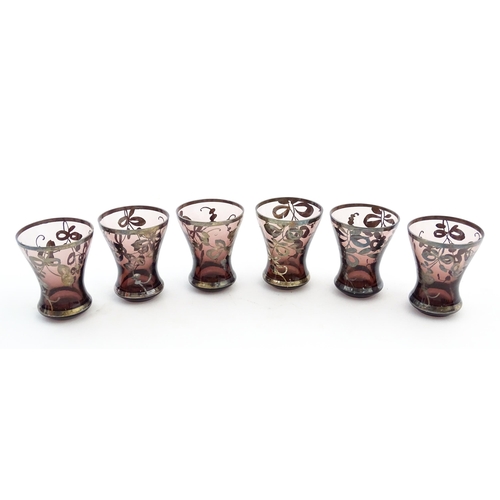 212 - An amethyst glass decanter and six tot glasses with silvered detail. Together with a further six gla... 