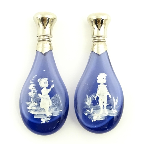 216 - Two 20thC blue glass perfume / scent bottles / flasks with Mary Gregory style decoration and white m... 