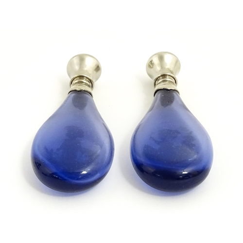 216 - Two 20thC blue glass perfume / scent bottles / flasks with Mary Gregory style decoration and white m... 