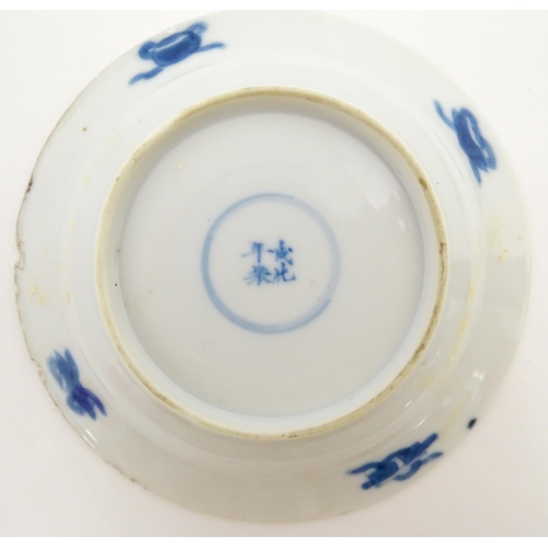 22 - A small Chinese blue and white dish decorated with figures in a landscape bordered by auspicious sym... 