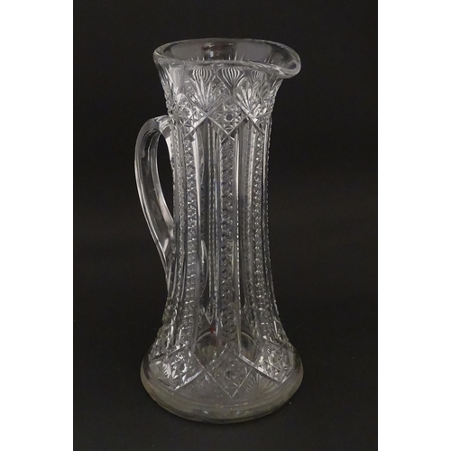 246 - A large cut glass water jug with loop handle. Approx. 12 3/4