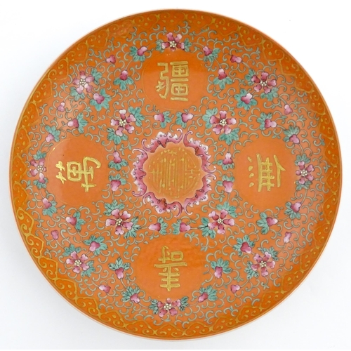 3 - A Chinese plate / dish with orange ground decorated with Character marks and scrolling floral and fo... 