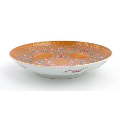 3 - A Chinese plate / dish with orange ground decorated with Character marks and scrolling floral and fo... 