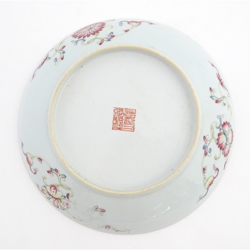 3 - A Chinese plate / dish with orange ground decorated with Character marks and scrolling floral and fo... 