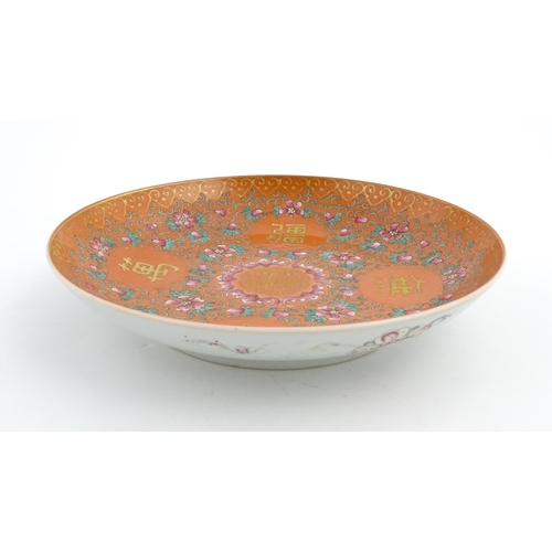 3 - A Chinese plate / dish with orange ground decorated with Character marks and scrolling floral and fo... 