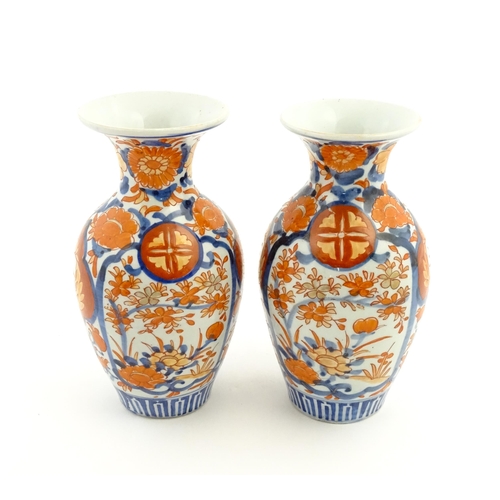 37 - A pair of Japanese vases of baluster form with flared rims decorated in the Imari palette with flowe... 