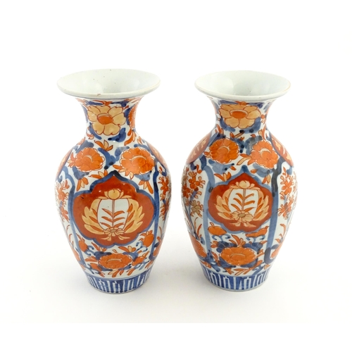 37 - A pair of Japanese vases of baluster form with flared rims decorated in the Imari palette with flowe... 