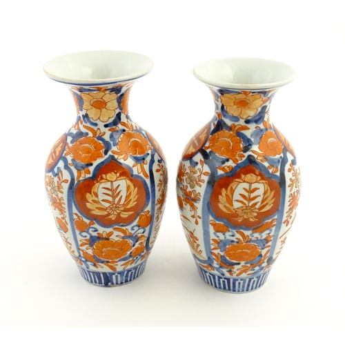 37 - A pair of Japanese vases of baluster form with flared rims decorated in the Imari palette with flowe... 