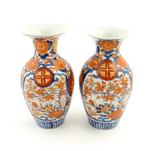 37 - A pair of Japanese vases of baluster form with flared rims decorated in the Imari palette with flowe... 