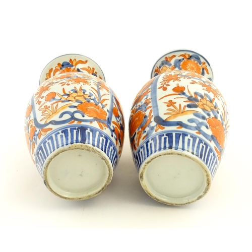 37 - A pair of Japanese vases of baluster form with flared rims decorated in the Imari palette with flowe... 