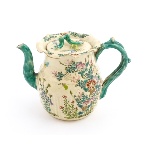 38 - A Japanese Satsuma teapot decorated with flowers, foliage and butterflies. Approx. 5