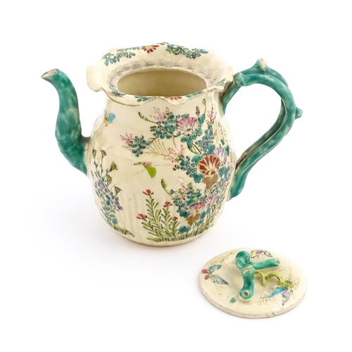 38 - A Japanese Satsuma teapot decorated with flowers, foliage and butterflies. Approx. 5