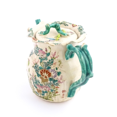 38 - A Japanese Satsuma teapot decorated with flowers, foliage and butterflies. Approx. 5