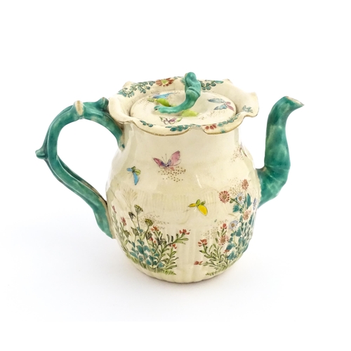 38 - A Japanese Satsuma teapot decorated with flowers, foliage and butterflies. Approx. 5