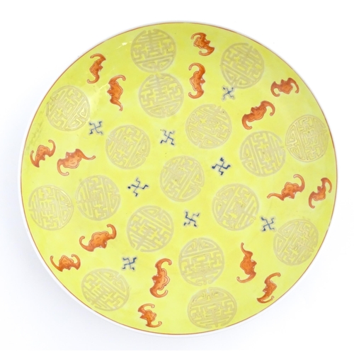 40 - A Chinese yellow ground plate decorated with bats and auspicious symbols. Character marks under. App... 