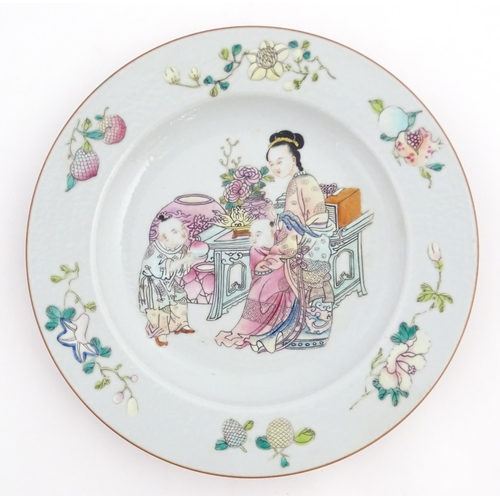 46 - A Chinese famille rose plate decorated with a lady and two children, with flowers and vase, bordered... 