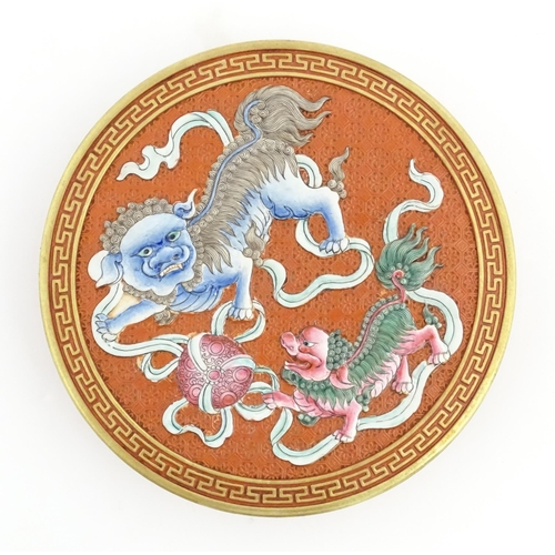 47 - A Chinese box of circular form with foo dog / guardian lion detail, with gilt border. Character mark... 